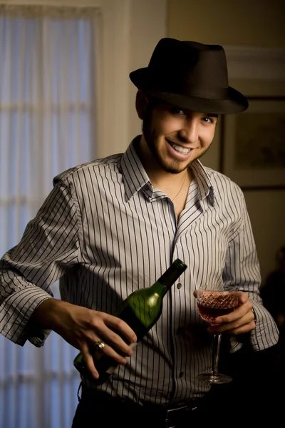 Ung man i en fedora med rött vin — Stockfoto