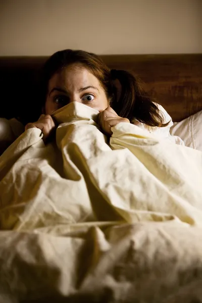 Mujer asustada en la cama — Foto de Stock