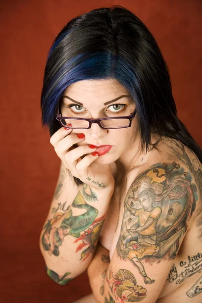 Vrouw met tatoeages en gekruiste armen — Stockfoto