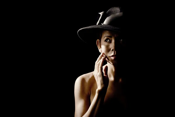 Femme dans l'ombre portant un chapeau noir — Photo