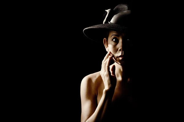 Femme dans l'ombre portant un chapeau noir — Photo