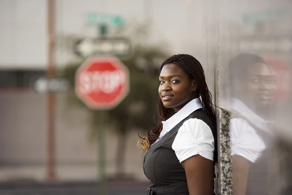 African american vrouw leunend tegen een gebouw — Stockfoto