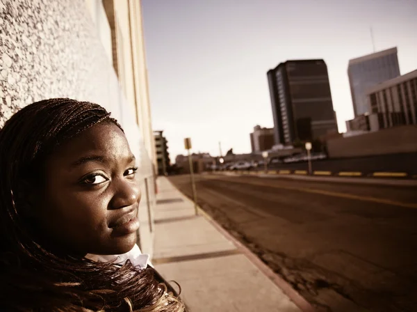 African american vrouw leunend tegen een gebouw — Stockfoto