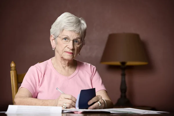 Senior vrouw betalen rekeningen — Stockfoto