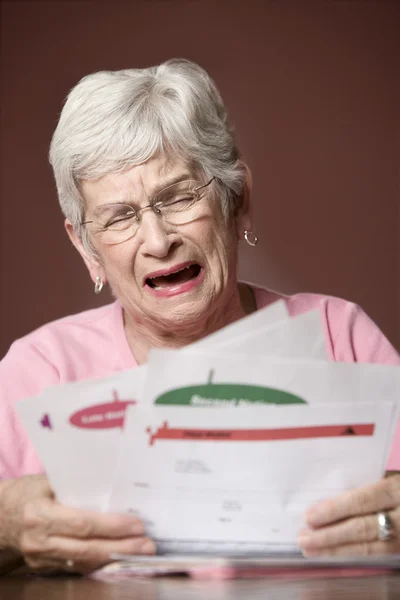 Senior vrouw met rekeningen en mededelingen — Stockfoto