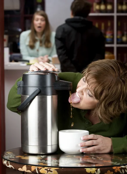 Mujer bebiendo café directamente de un dispensador — Foto de Stock