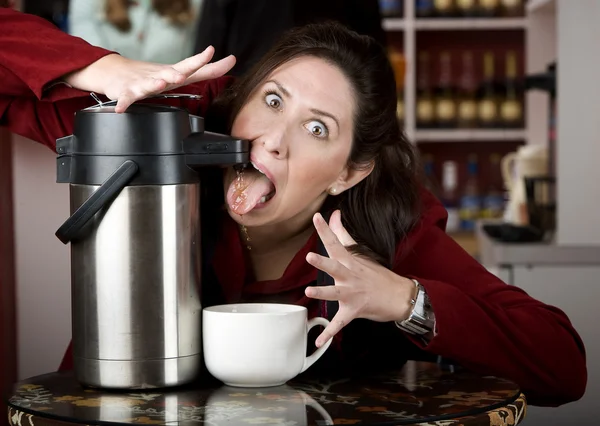Woman drinking coffee directly from a dispenser — Stock Photo, Image