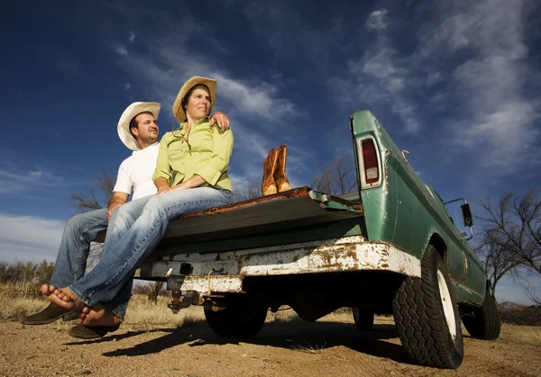 Cowboy and woman on pickup truck — Stock Photo, Image