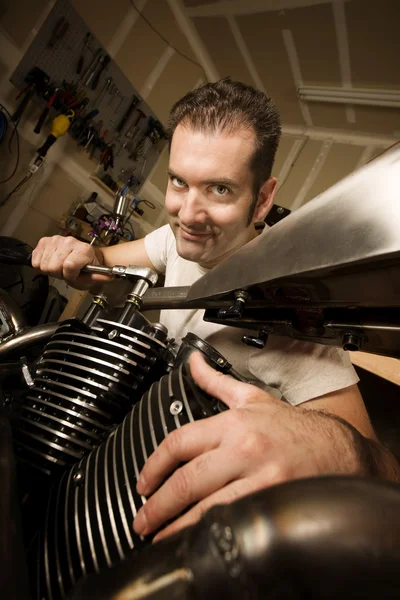 Homme dans le garage travaillant sur la moto — Photo