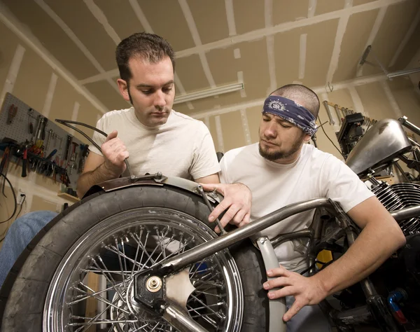 Zwei Motorradmechaniker platzieren einen Schutzblech — Stockfoto