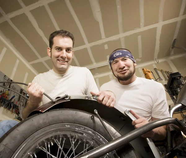 Deux mécaniciens de moto plaçant une aile — Photo