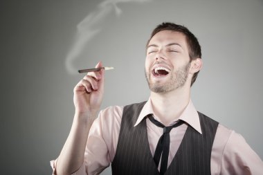 küçük puro ile genç adam gülüyor