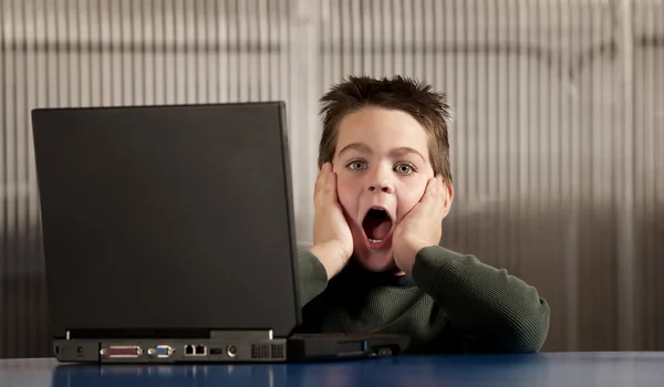 Geschokt jongen met een laptopcomputer — Stockfoto