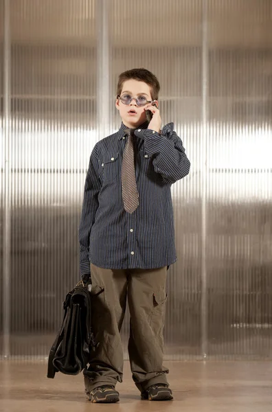 Kleiner Junge in Erwachsenenkleidung am Handy — Stockfoto
