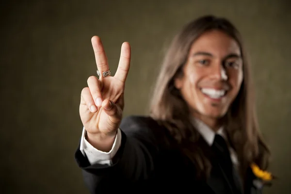 Schöner Mann in Formalbekleidung, der ein Friedenszeichen setzt — Stockfoto