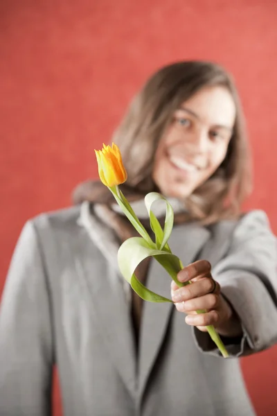 Przystojny młody mężczyzna z żółty tulipan — Zdjęcie stockowe