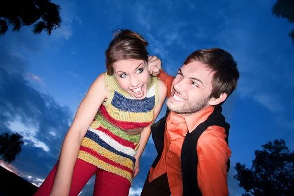 Jovem casal brincando ao pôr do sol — Fotografia de Stock