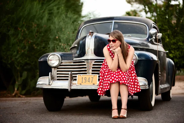 Дівчина в червоному з старовинною машиною — стокове фото