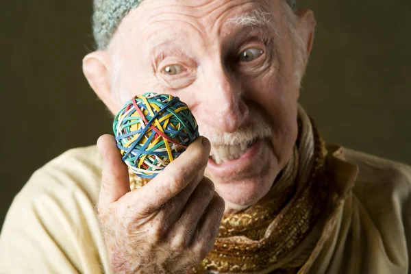 Man contemplating a rubber band ball — Stock Photo, Image