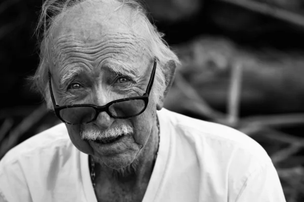 Oudere man in t-shirt en glazen — Stockfoto