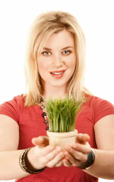 Pretty blonde woman with grass in small pot — Stock Photo, Image