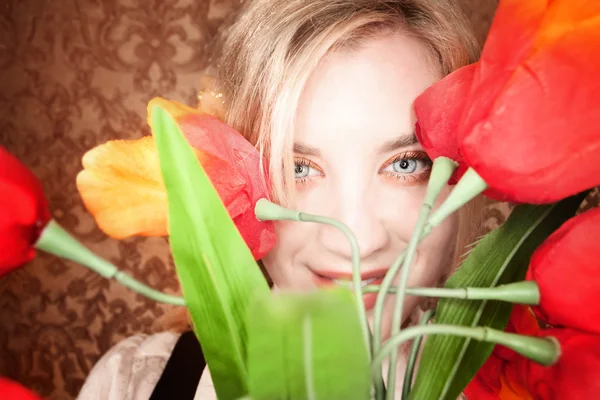 Mujer rubia bastante joven con flores de plástico —  Fotos de Stock