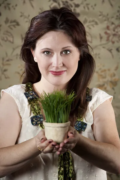 Mulher com pote pequeno de grama verde — Fotografia de Stock