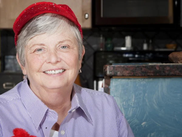 Femme âgée portant un chapeau rouge — Photo