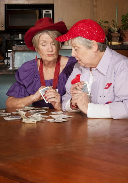 Senhoras vestindo chapéus vermelhos jogando cartas — Fotografia de Stock