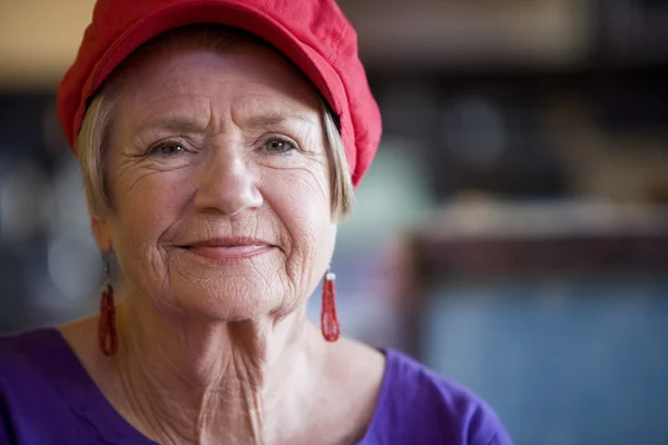 Donna anziana con il cappello rosso — Foto Stock