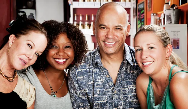 Мужчина с тремя красивыми женщинами в кофейне — стоковое фото