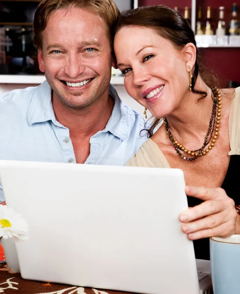 Casal atraente com computador portátil — Fotografia de Stock