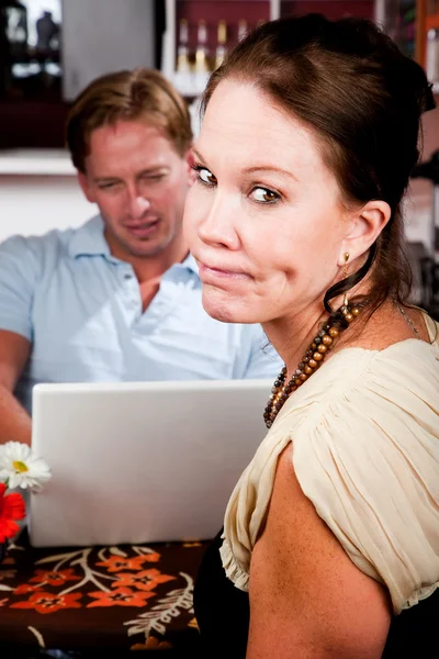 使用便携式计算机在咖啡屋中忽略他的约会对象的人 — 图库照片