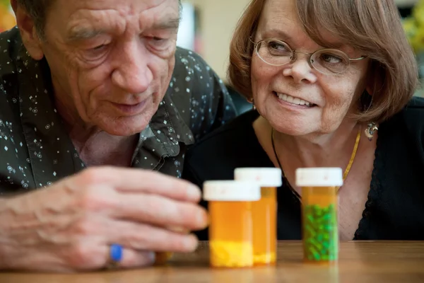 Пара пожилых людей, изучающих лекарства — стоковое фото
