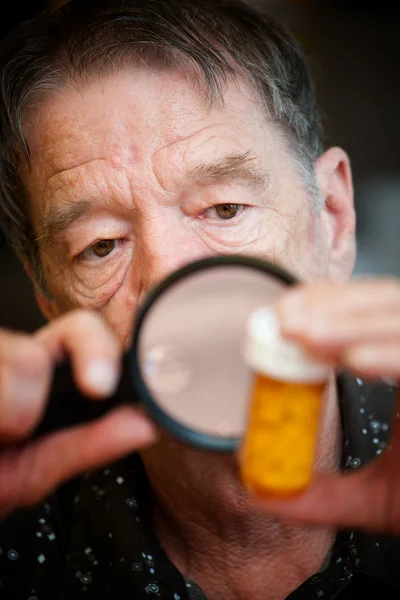 Homme âgé examinant des médicaments — Photo