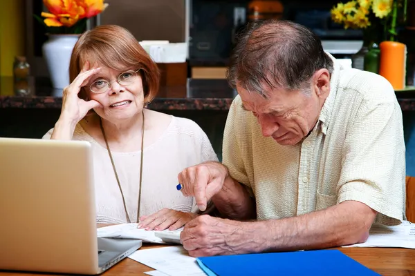 Äldre par hemma med många räkningar — Stockfoto