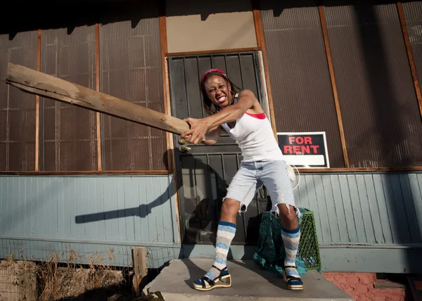 Woman swinging a board — Stock Photo, Image