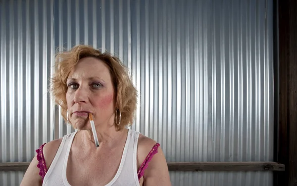 Woman smoking in front of corrugated metal — Stock Photo, Image