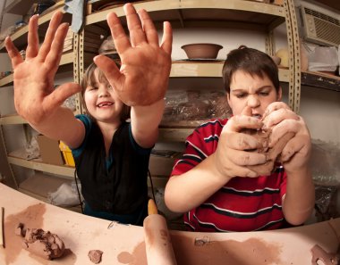Kids with messy hands in clay studio clipart