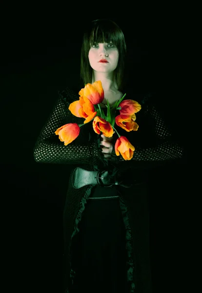Menina gótica com tulipas de plástico — Fotografia de Stock
