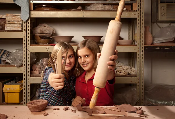 Chicas jóvenes con herramientas en el estudio de arcilla — Foto de Stock