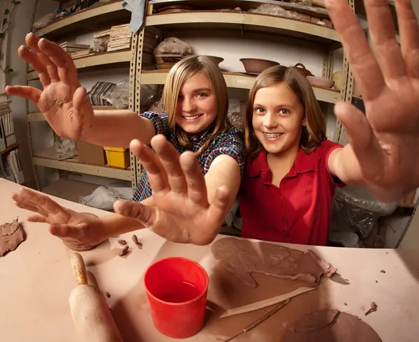 Mignonnes jeunes filles dans un studio d'argile tenant leurs mains — Photo