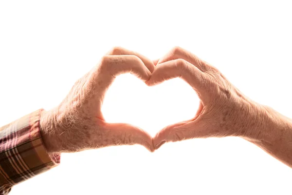 Coppia anziana formando cuore con le mani — Foto Stock