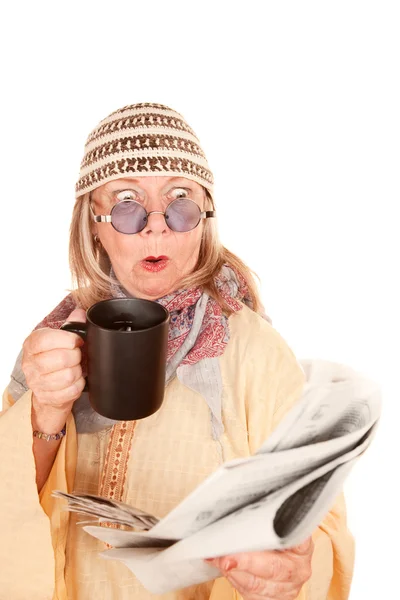 Gek nieuwe leeftijd vrouw in een gele gewaad met koffie — Stockfoto