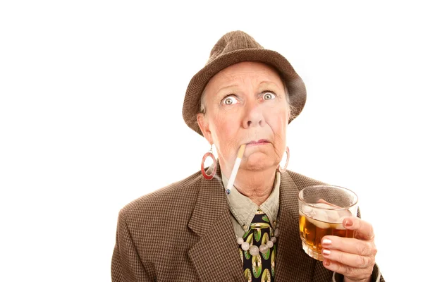 Старшая женщина в мужской одежде с сигаретой и напитками — стоковое фото