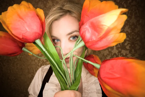 Pretty young blonde woman with plastic flowers — Stock Photo, Image