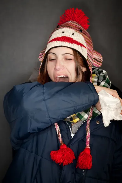 Žena kýchání do její paže — Stock fotografie