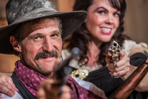 Cowboy och saloon girl punkt vapen — Stockfoto