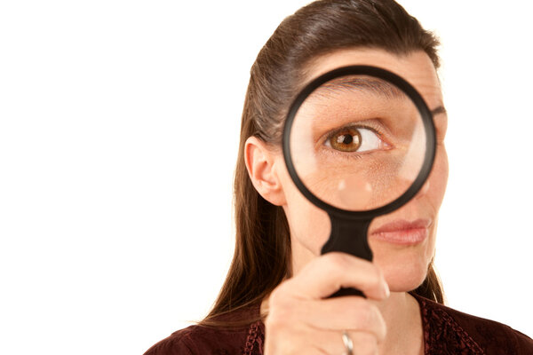 Pretty adult woman using magnifying glass