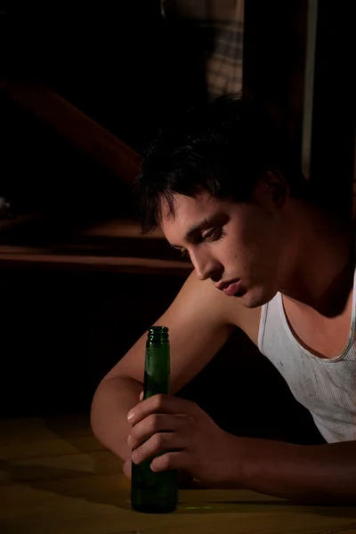 Depressed young man with beer bottle — Stock Photo, Image